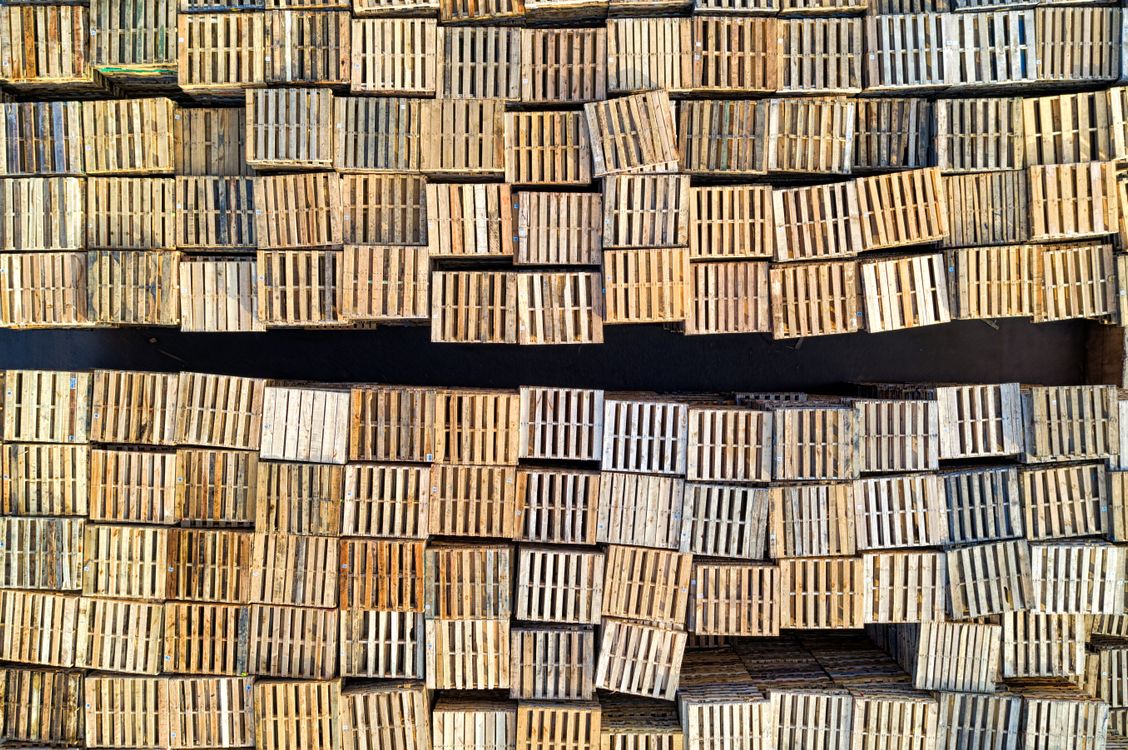 Wooden shipping pallets stacked in a storage area